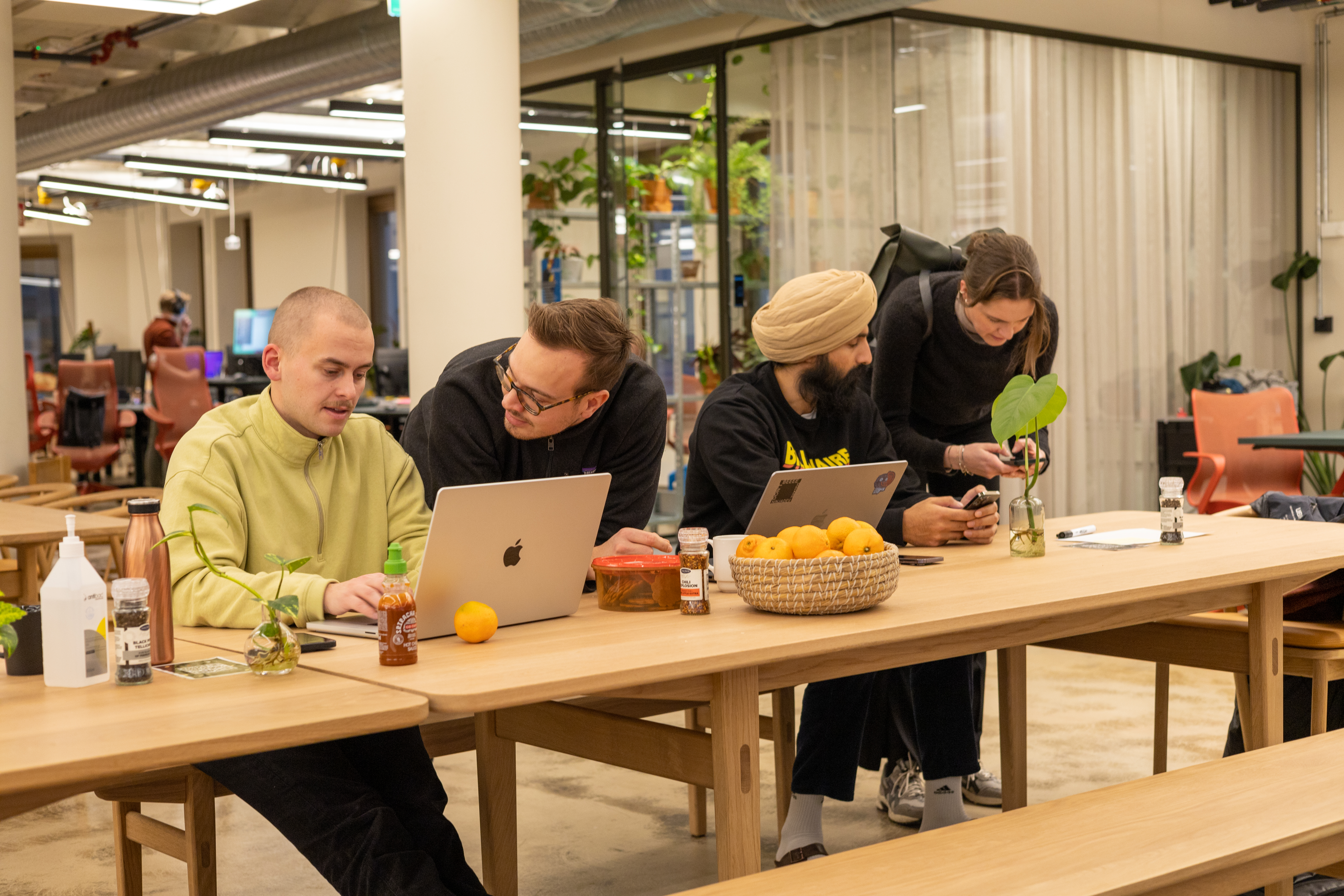 Image of four people talking and looking at screens